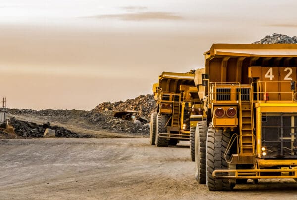 Mining Insurance - Mining Dump Trucks Transporting Coal for Processing From a Large Mine at Dusk