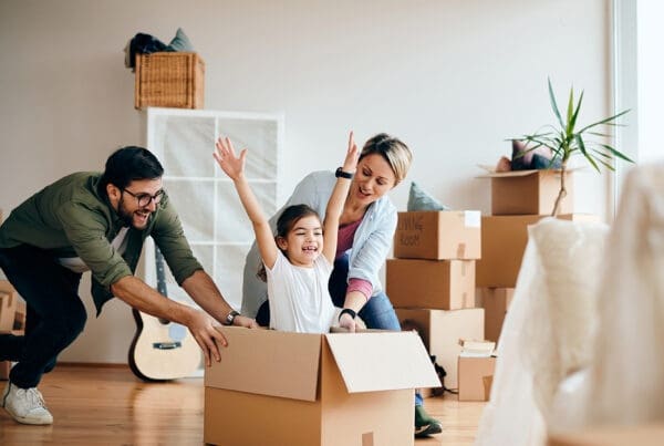 Personal Insurance - Fun family pushing their child in a cardboard box in their new home