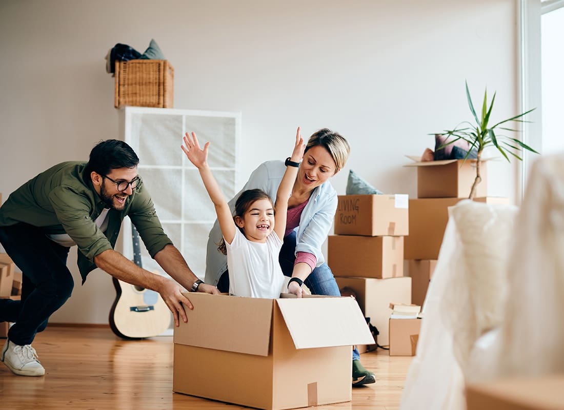 Personal Insurance - Fun family pushing their child in a cardboard box in their new home